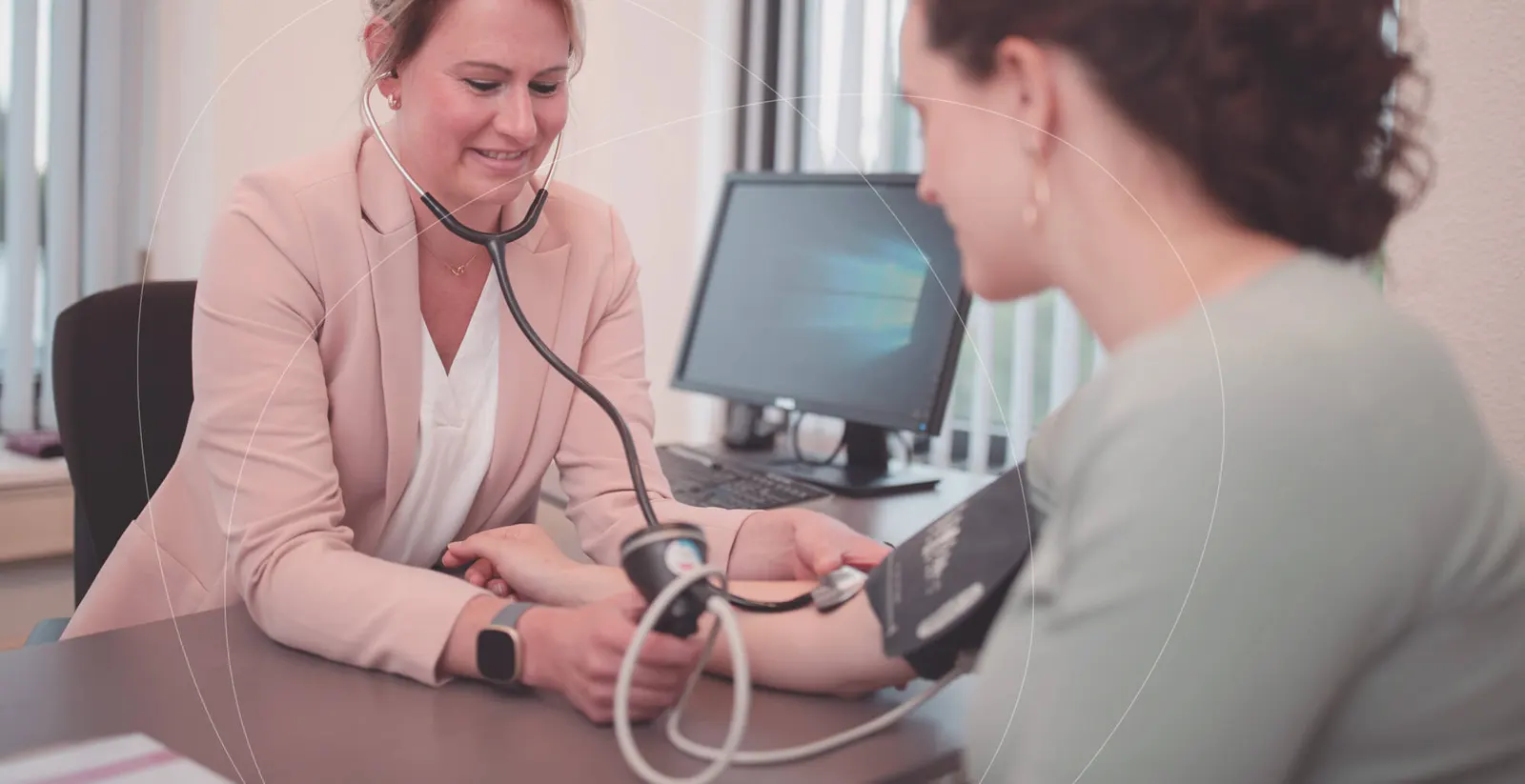 Verloskundige meet de bloeddruk van een zwangere vrouw